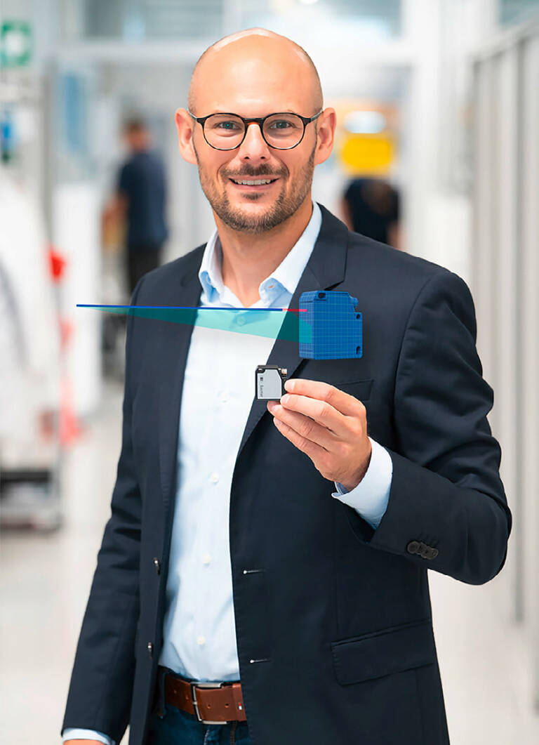 Dominik Unger, Business Development Manager, montre l'un des outils intelligents de Baumer pour les designers : le jumeau numérique du capteur de distance laser OM20 avec tracé du faisceau. © Baumer