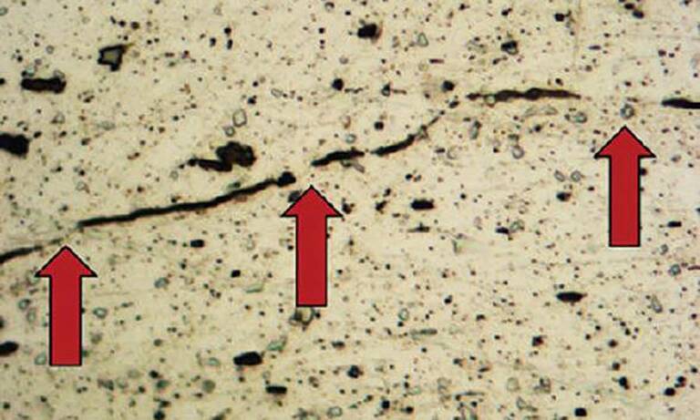 Micrographie placée sous microscope d’un assemblage par clinchage.&nbsp;
Les flèches indiquent les microcontacts réalisés entre 2&nbsp;pièces/matériaux.
© Tox Pressotechnik
